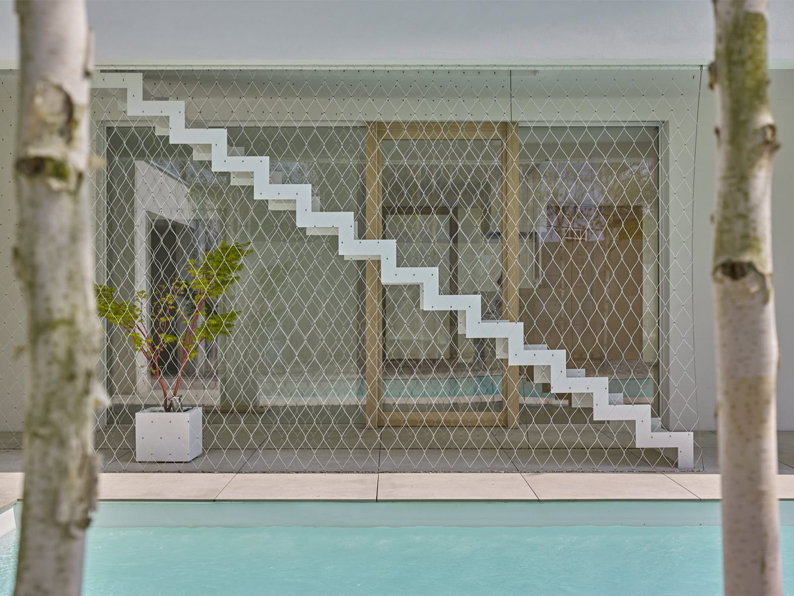 Villa par Stéphane Herrgott — escalier suspendu et baies vitrées côté bassin
